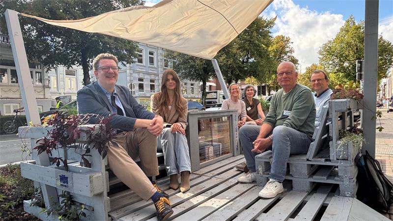 Prof. Dr. Karsten Ley (links), Architekturstudentin Nina Garbers (Zweite von links) sowie Mitglieder des Vereins Buxtehude im Wandel nehmen zur Einweihung Platz.