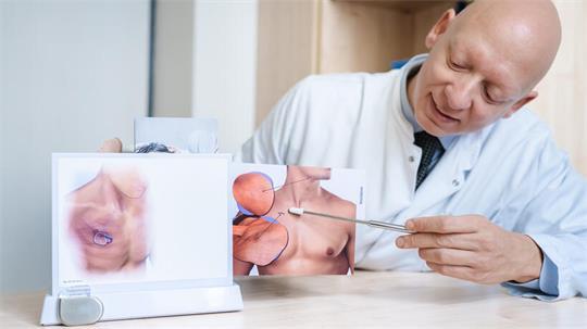 Professo. Dr. Ozan Gökler, Leitender Oberarzt der HNO-Klinik am Elbe Klinikum Stade, erklärt anhand eines Modells, wo der Zungenschrittmacher implantiert wird.
