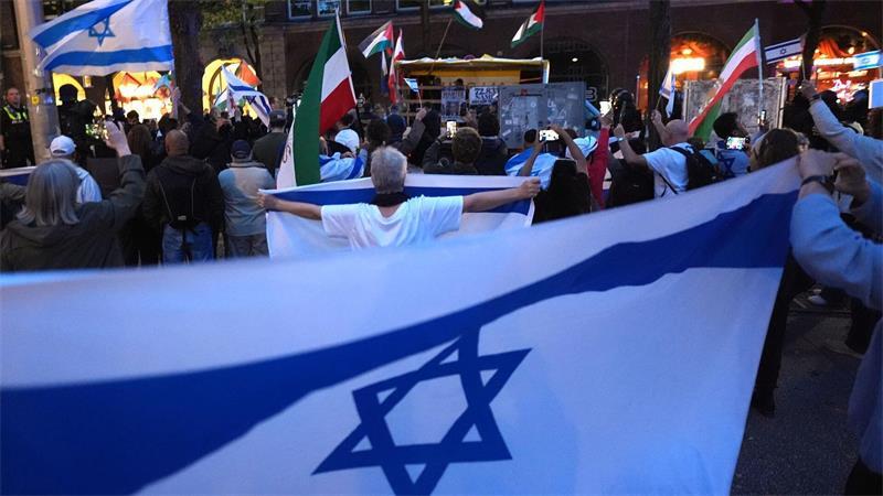 Proisraelische Demonstranten zeigen Flagge, während ein propalästinensischer Demonstrationszug durch den Stadtteil St. Georg geht. 