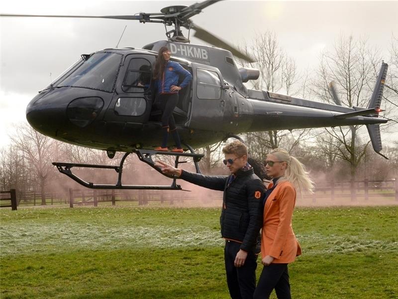 Promi Sarah Knappik steht neben Jens Langenfurth unter dem Helikopter, oben lehnt sich Andrina Viebrock mutig aus der geöffneten Tür.