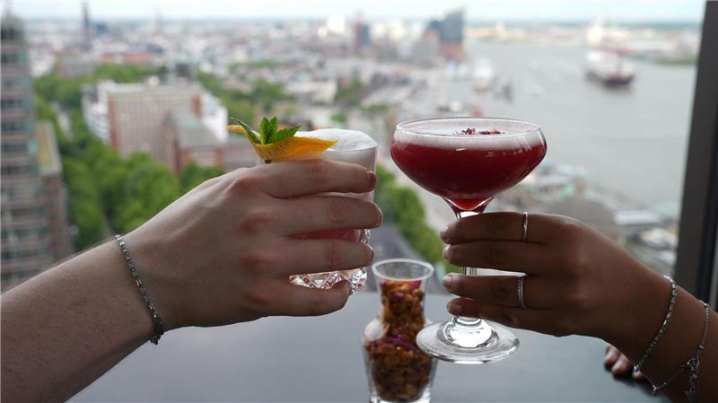 Prost mit Cocktails: Viele berichten einer Umfrage zufolge, dass sie weniger ausgehen und auch weniger ihre Freunde treffen angesichts der Inflation der letzten Jahre.