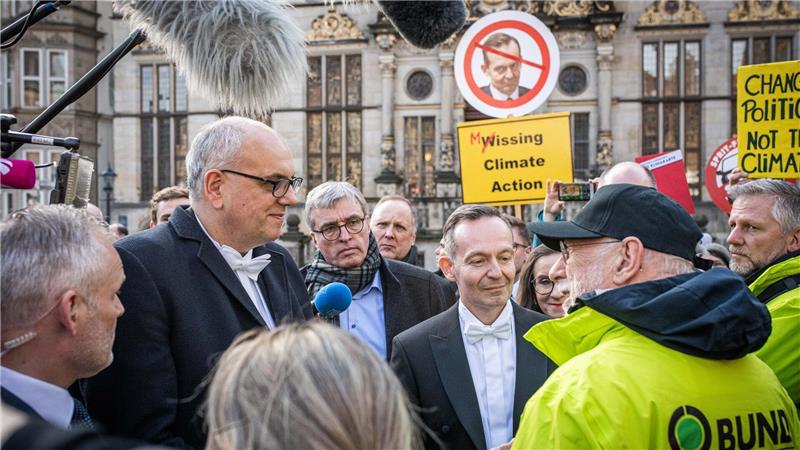 Bremer Schaffermahlzeit mit Protestgetöse und Klebe-Aktivisten Proteste bei der Schaffermahlzeit: Der Unmut der Umweltverbände richtete sich gegen Bundesverkehrsminister Volker Wissing (FDP, Mitte). Foto: Arnd Hartmann