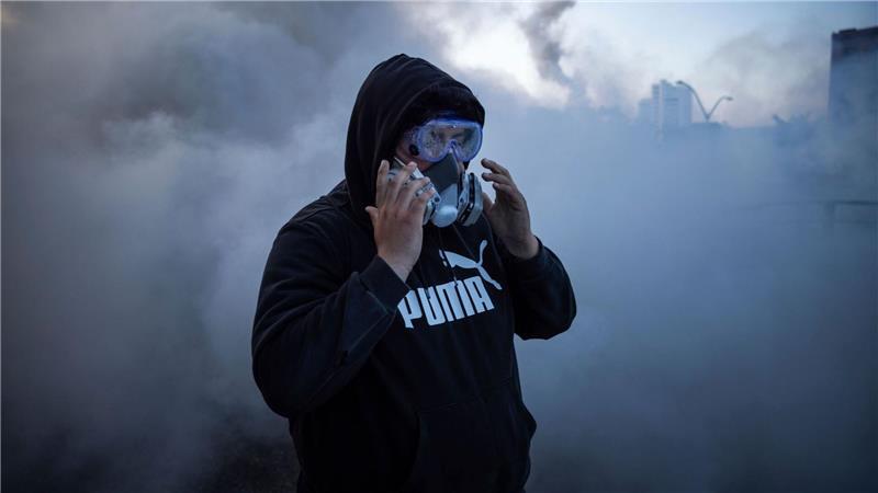 Proteste gegen Aktion von US-Bundeseinwanderungsbehörde - Eine Person reagiert auf Reizstoffe bei Protesten in der Nähe des Metropolitan Detention Center in Los Angeles. 