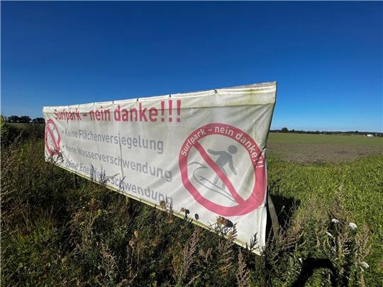 Protestschild auf dem Acker südlich von Stade-Ottenbeck, wo noch 2024 perfekte Wellen geritten werden sollen - wenn es nach Plan geht. Foto: Richter