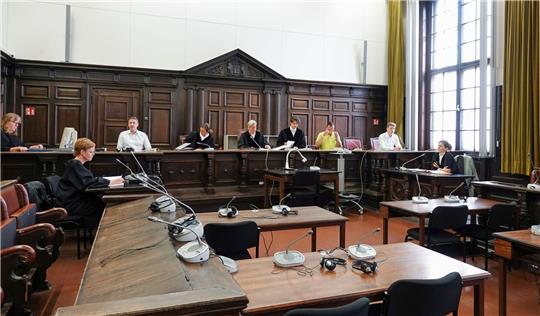 Prozessbeteiligte sitzen vor Beginn des Sicherungsverfahrens wegen Totschlags im Gerichtssaal im Strafjustizgebäude.