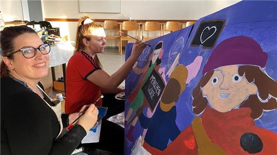Public Painting in St. Paulus: Illustratorin Marlies Abramowski (links) und Helferin Edina Radics pinseln an den letzten gestalterischen Details der Bootsbemalung.