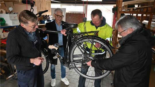 Rainer Matthias, Schulleiter Olaf Hesse, Kay Oestmann und Seniorenbeauftragter Kai Schlecht (von links) reparieren in der neuen Werkstatt an der Oberschule in Jork ein Fahrrad.