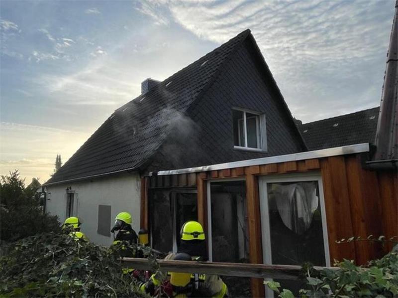 Feuer in Cuxhaven: Flammen kommen gefährlich nah an weiteres Gebäude Rauch steigt aus dem beschädigten Haus in Altenwalde auf, während Einsatzkräfte Glutnester aufspüren.