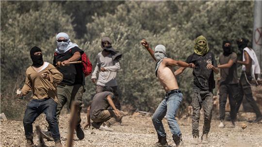 Rechtsgerichtete israelische Siedler werfen Steine auf palästinensische Dorfbewohner während eines Angriffs auf das Dorf im Westjordanland Turmusaya.