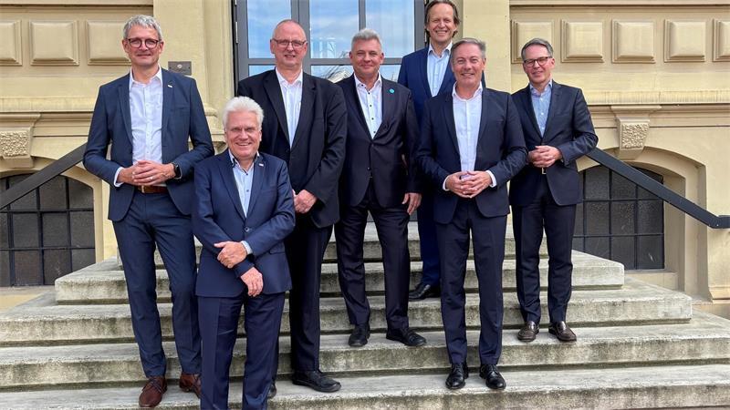Experten in Buxtehude: Bringt der Bauturbo mehr bezahlbare Wohnungen? Referenten und Gastgeber des 6. Tages der Bauwirtschaft vor dem Eingang der Hochschule 21 (von links): Sönke Pickenpack (Arbeitskreis Bauen im Bestand im Bauindustrieverband Niedersachsen-Bremen), Prof. Dr. Ingo Hadrych (Präsident Hochschule 21); Dr. Olaf Joachim (Staatssekretär im Bundesministerium für Wohnen, Stadtentwicklung und Bauwesen), Dr. Olaf Drude (WK Consult), Marcus Hübner (Geschäftsführer Hochschule 21), Immobilienanalyst Prof. Dr. Thomas Beyerle und Dr. Olaf Krüger (Süderelbe AG)