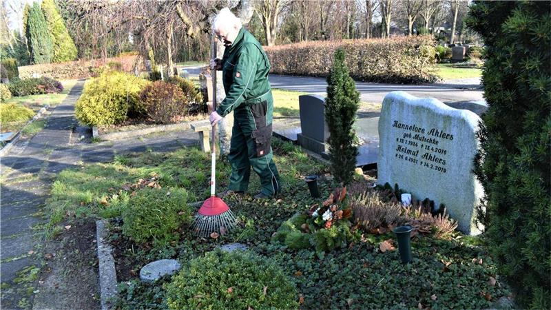 Statt Schottergräbern: Was Angehörige auf dem Friedhof pflanzen sollten Regelmäßige Pflege muss sein, auch im Winter: Friedhofsgärtner Joachim Scharnberg recht das Laub von einem Grab auf dem Langener Friedhof. Foto: Schoener