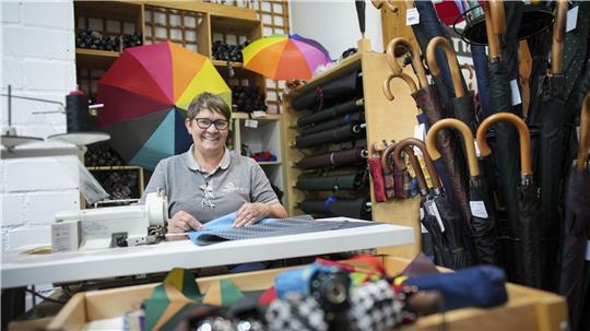 Regenschirm-Händlerin Meike Vertein sitzt an einer Nähmaschine in ihrem Laden „Schirm & Co“ in der Innenstadt von Hamburg.