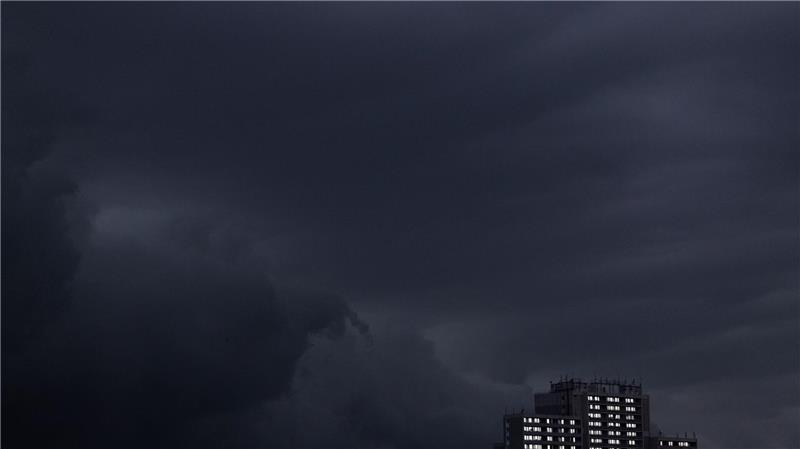 Regenwolken sind am Abendhimmel über einem Haus in Köln zu sehen.