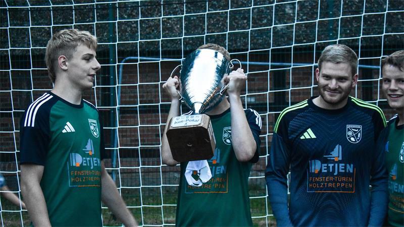 Reihum wird der Aue-Pokal gereicht; jeder Ahrenswohlder Spieler darf einen Schluck Kaltgetränk aus ihm nehmen.