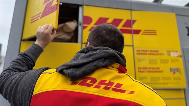 Rein in den Automaten, damit der Empfänger die Sendung später abholt: ein DHL-Paketbote bei der Abgabe von Sendungen an einer DHL-Packstation.
