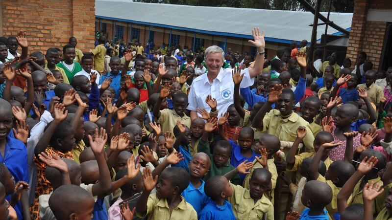 Reiner Meutsch mit Kindern vor einem Schul-Neubau in Afrika.