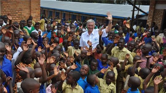Reiner Meutsch mit Kindern vor einem Schul-Neubau in Afrika.