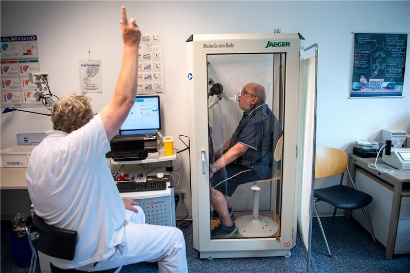 Reinhard Janzen sitzt zur Überprüfung seiner Lungenfunktion in einem Bodyplethysmographen. In der Klinik am Teutoburger Wald werden Long-Covid-Patienten behandelt. Foto: Sina Schuldt/dpa