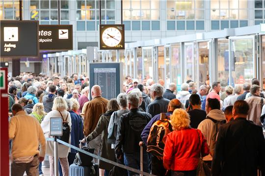 Reisende warten in langen Schlangen vor der Sicherheitskontrolle am Flughafen Hamburg auf die Abfertigung. Foto: Bodo Marks/dpa