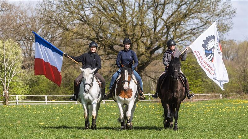 Reiterinnen trainieren mit Pferden der Karl-May-Spiele das Reiten zwischen wehenden Fahnen.