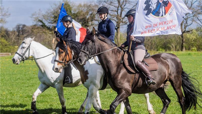 Reiterinnen trainieren mit Pferden der Karl-May-Spiele das Reiten zwischen wehenden Fahnen.