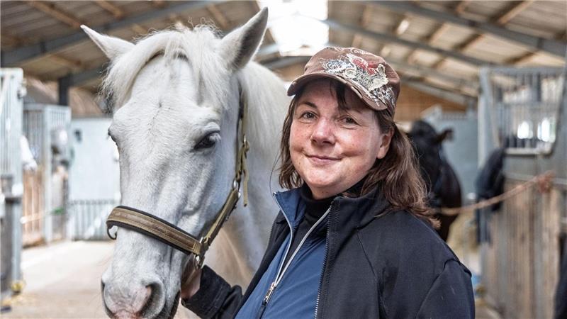 Reitstallchefin Sylvia Kassel steht mit dem Schimmel „Meloso“ im Pferdestall der Karl-May-Spiele auf dem Reiterhof Behnk.