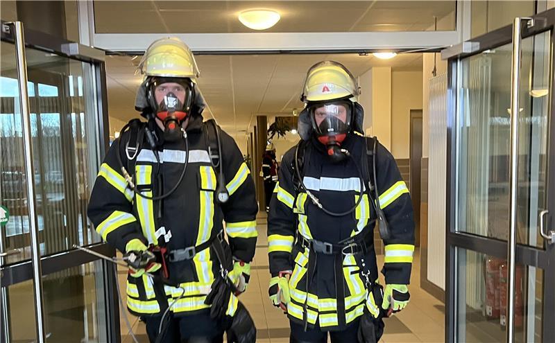 Reizgas-Alarm: Unter Atemschutz waren die Feuerwehrleute in den Neubau der Berufsbildenden Schule III in Stade vorgerückt, zwei Feuerwehrleute kommen von der Messung zurück.