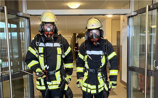 Reizgas-Alarm: Unter Atemschutz waren die Feuerwehrleute in den Neubau der Berufsbildenden Schule III in Stade vorgerückt, zwei Feuerwehrleute kommen von der Messung zurück.