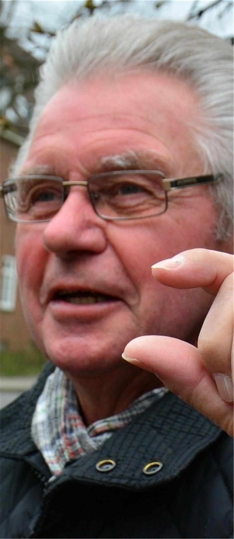 Rentner Hans-Hermann Psik zeigt, wie hoch die störenden Kanten am Bahnübergang sind.