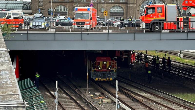Rettungskräfte stehen an den Gleisen.