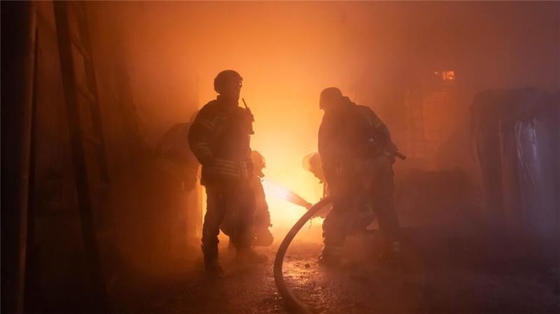Rettungskräfte arbeiten an einem brennenden Gebäude im Stadtteil Slobidskij von Charkiw.