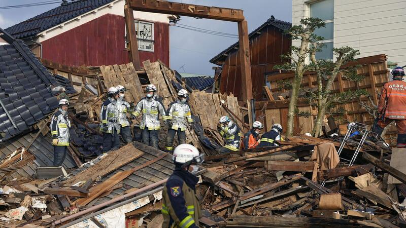 Mehr als 200 Menschen in Japans Erdbebengebiet vermisst Rettungskräfte arbeiten an einem eingestürzten Gebäude in Wajima.