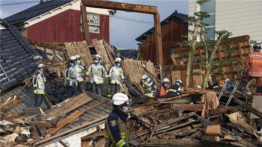 Rettungskräfte arbeiten an einem eingestürzten Gebäude in Wajima.