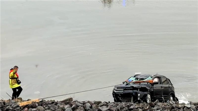 Rettungskräfte befreiten eine Person aus dem im Wasser versinkenden Fahrzeug.