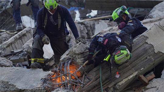 Rettungskräfte durchtrennen Trümmer bei der Suche nach Überlebenden.