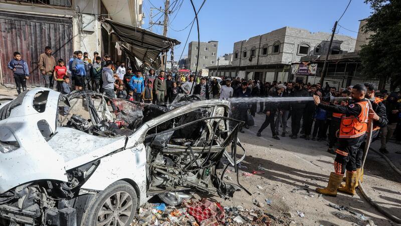 Rettungskräfte löschen die Überreste eines Autos. Drei Palästinenser kamen bei dem israelischen Angriff ums Leben.