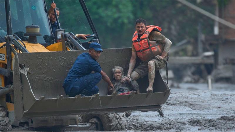 Rettungskräfte setzen am Trishuli-Fluss einen Radlader ein, um ein Opfer der Sturzflut in Sicherheit zu bringen.