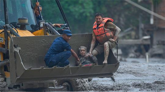 Rettungskräfte setzen am Trishuli-Fluss einen Radlader ein, um ein Opfer der Sturzflut in Sicherheit zu bringen.