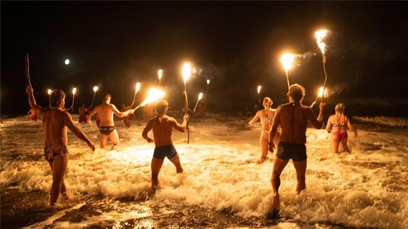 Rettungsschwimmer in Mar Azul, Argentinien, waten mit Fackeln in den Atlantik, um den Tag der Rettungsschwimmer zu begehen.
