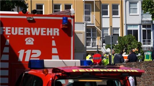 Rettungswagen, Polizisten und Polizeifahrzeuge stehen in der Nähe des Einsatzortes.