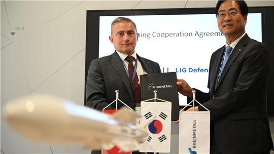 Rheinmetall-Manager Oliver Dürr und der südkoreanische Manager Ickhyun Shin nach der Unterschrift der Vereinbarung bei der Eurosatory.