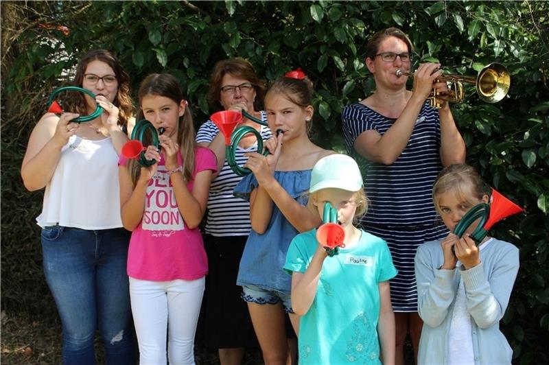 Ricarda Behrens, Petra Behrens und Wiebke Timm (hintere Reihe von links) mit den Teilnehmern des Kinder-Orches- ters Miriam, Viktoria, Pauline und Jule und den selbst gebauten Trompeten. Foto: Frank