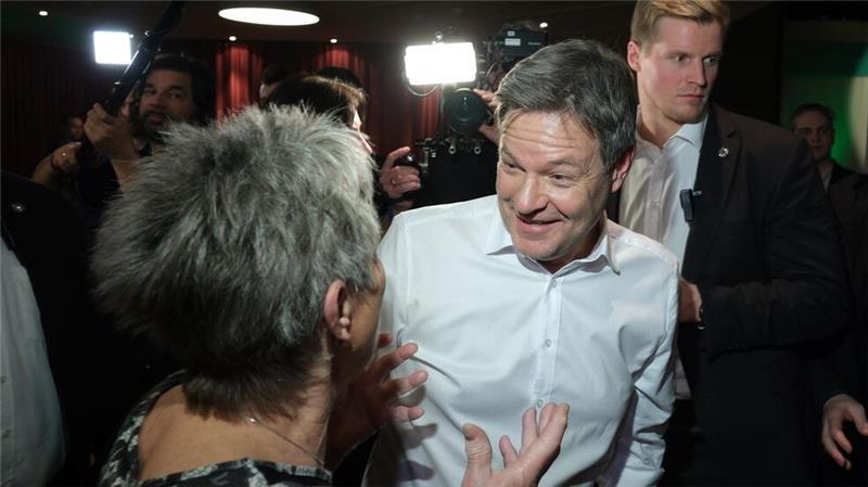 Robert Habeck spricht bei einer Wahlkampfveranstaltung in Leipzig mit einer Besucherin.