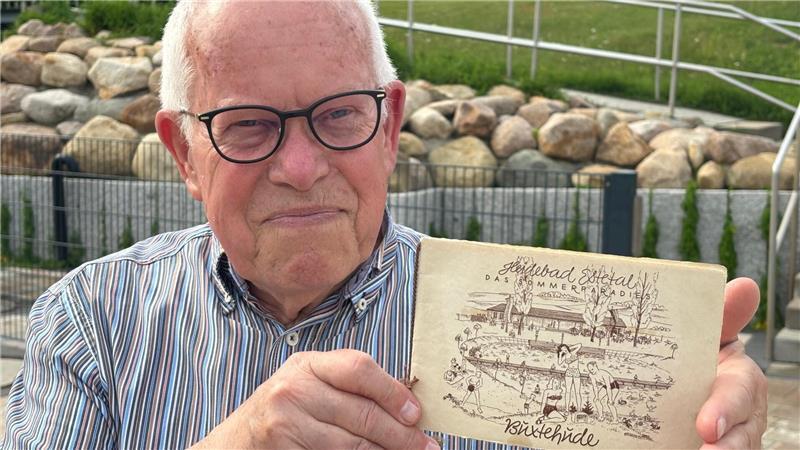 Robert Kamprad zeigt die aufwendig gestaltete Einladungskarte zur Einweihung des Heidebads im Jahr 1950. Das Dokument aus seinem Besitz hat er den Stadtwerken überlassen.