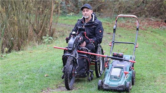 Rollo, der engagierte Rollstuhlfahrer, hat sich eine eigene Konstruktion gebaut, um mit dem Rasenmäher die kleine Grünanlage hinter dem Ritzebütteler Marktplatz zu pflegen.