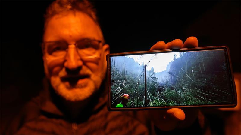 Roman Rolof, Bürgermeister von Rathen, zeigt nach schweren Unwettern ein Foto von Schäden auf seinem Smartphone, das er selbst aufgenommen hat.