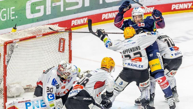 Ross Mauermann (r) und Nicolas Appendino (3.v.r) von Pinguins Bremerhaven verteidigen das Tor.