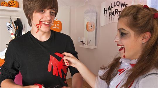Rotes Gewebeband imitiert Blut: Ausgeschnittene Tropfen und Streifen lassen sich auf ein ausgedientes schwarzes Shirt kleben. 