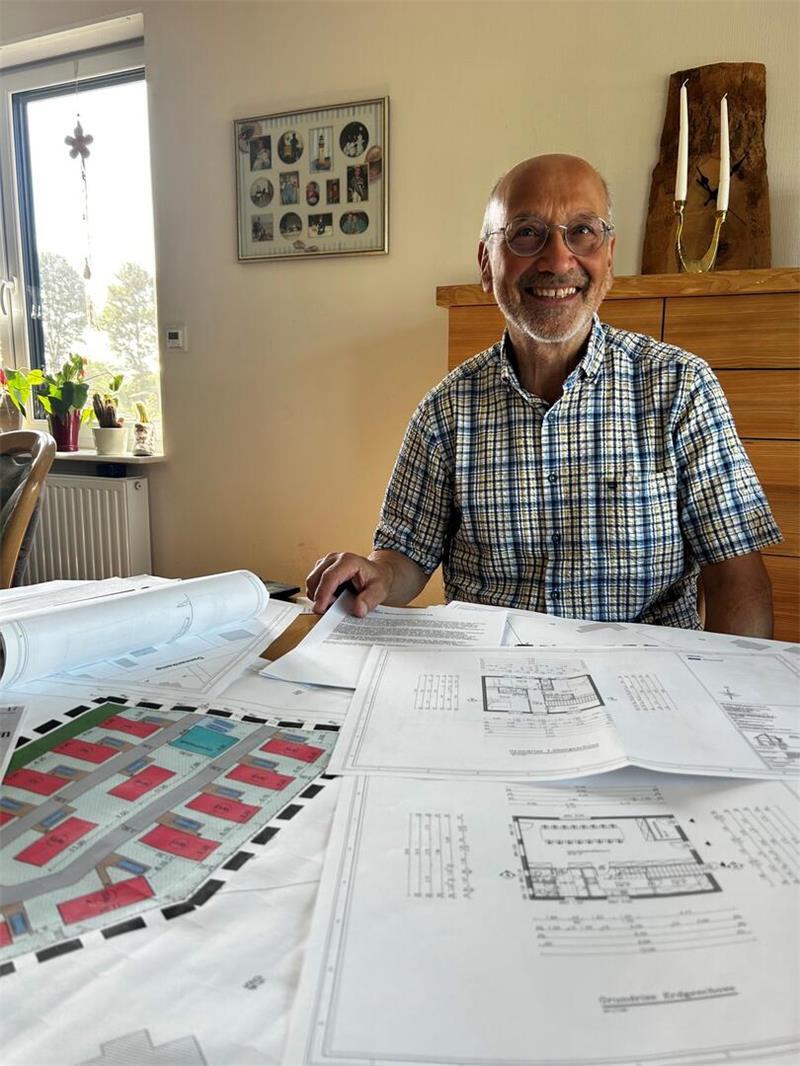 Rudolf Mundt hält den Plan der Pueblo-Wohngemeinschaft in der Hand. Auf seinem Grundstück ist Platz für 16 Kleinhäuser.