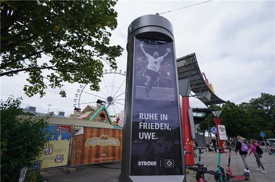 "Ruhe in Frieden, Uwe." steht unter einem Foto des verstorbenen Ehrenspielführers der Nationalmannschaft, Uwe Seeler, auf einer digitalen Werbesäule am Eingang des Hamburger Sommerdoms 2022. Foto: Marcus Brandt/dpa